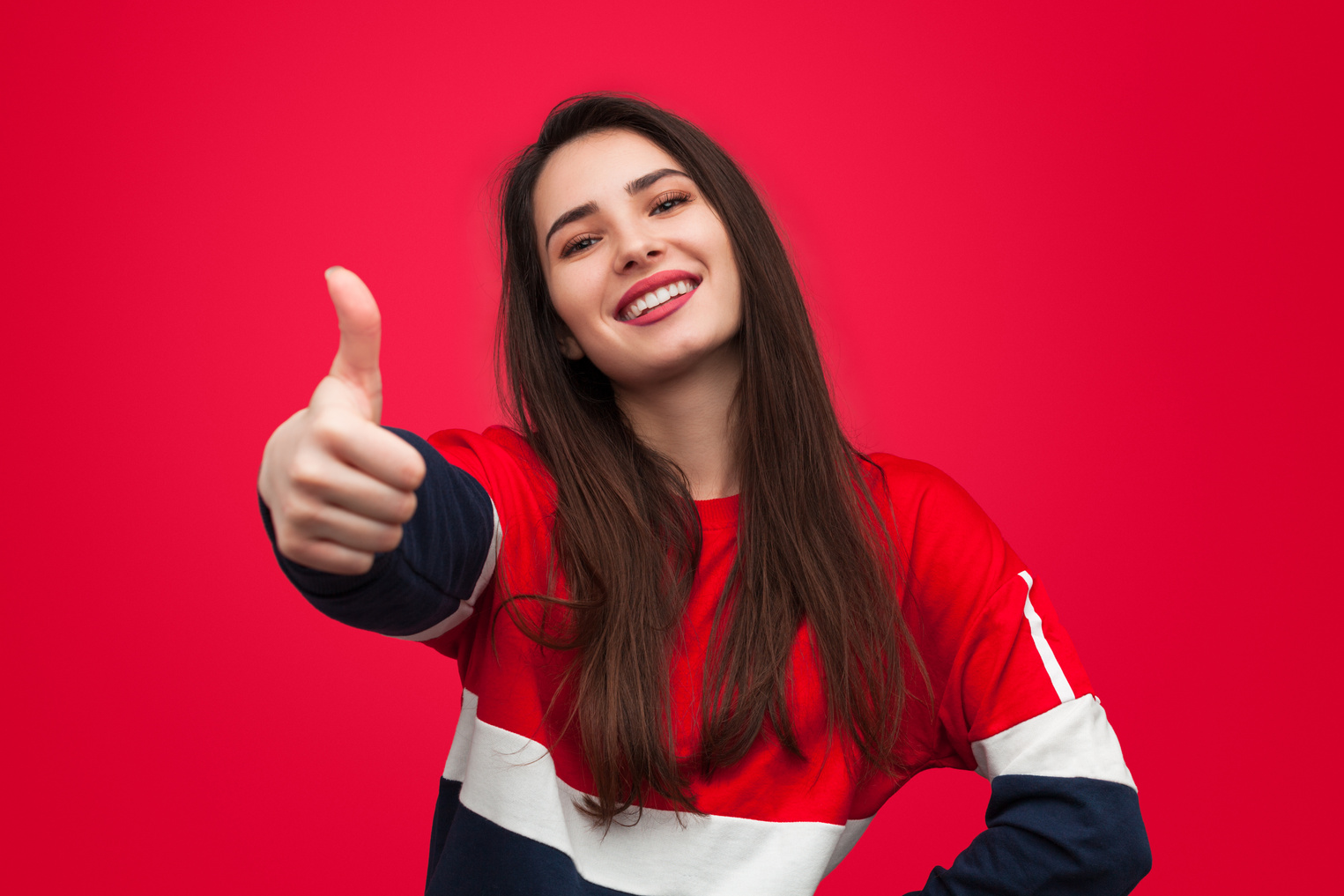 Cheerful woman gesturing thumb-up